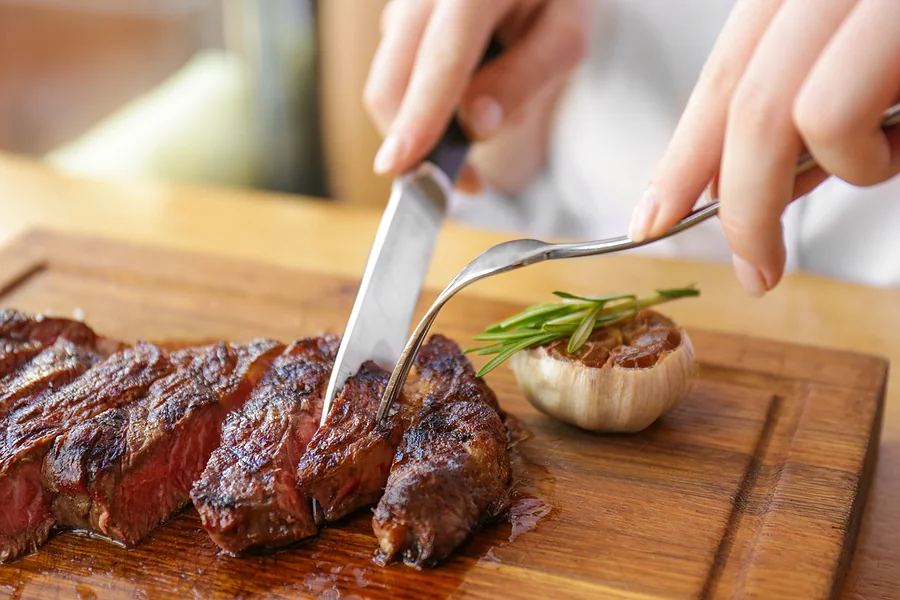 Woman cutting into a steak